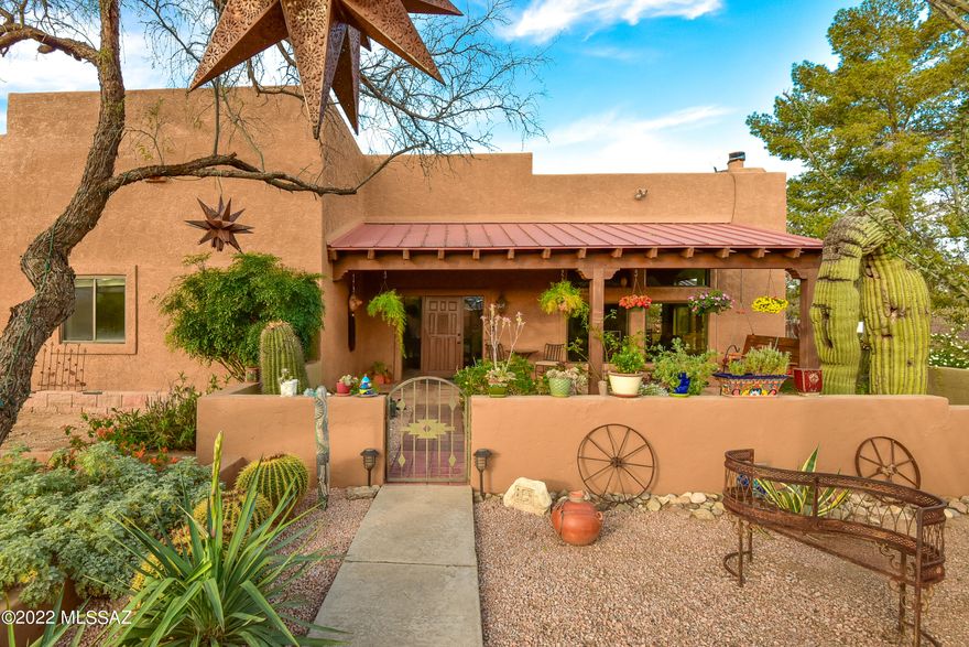 You will fall in love with this exceptional Santa Fe home, customized and updated inside and out with an artistic touch! From the courtyard entry to amazing patio with elegant arches, this home was made for entertaining!  Great room features 12' high wood beam ceilings & cozy corner fireplace.
Gourmet kitchen with double oven gas top range, copper apron sink, custom alder cabinetry, wine cooler, granite countertops & walk in pantry. Luxurious Owner's suite features 2 walk in closets plus spa-like bath 
with huge travertine shower, claw foot tub, double vanity with granite top, designer storage mirrors & copper sinks, plus private patio with hot tub and outdoor shower. 2 additional large bedrooms with high ceilings plus a Guest suite or office that has a pass through bath and.... private entry from patio. 
Outdoors, you will find a detached, 800+ sq ft extended garage, RV space, a refreshing 
newer salt water, pebbletech swimming pool with waterfall, ramada and firepit seating to enjoy the 
Catalina mountain views...
plus additional fireplace and seating area in front yard, live the Arizona lifestyle!  Great location close to MacDonald Park, hiking, golf and many outdoor activities. Recent mechanical updates, 19.5 Seer TRANE HVAC in 2018, both water heaters 2019, Water softener system in place since 2013, Roof coated/serviced 2022.  This gem is special and a must-see home!