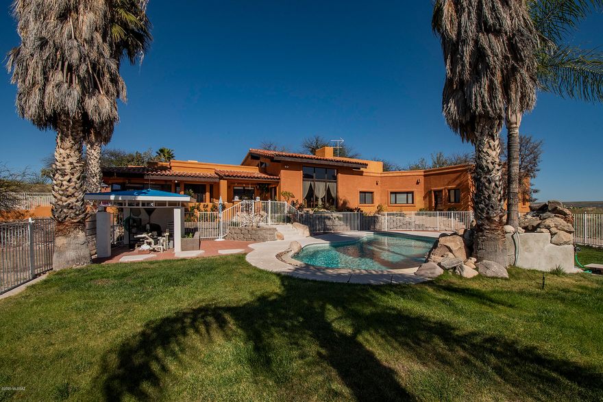 ONE of kind VIEWS  from luxurious  Master bedroom, impeccable living room, and covered patio for breakfast.
National forest at back with Catalina Mts, over 50000 acres of trails to explore. Its like an island, with no neighbors. Has horse privileges, for riding and reflecting Set on 6.8 acres of beautiful rolling hills for elbow room. Has private offices and library to really be comfortable for working at home. The pool is just the right size. If you have a calling for horticulture there is a Green House to get in touch with nature. There is a LOT more!! Vacuum system, multiple a/c,evaporate cooling units, solar hot water heater, additional  pad of 25'x25 to  build  a workshops, Guest house two bedrooms.1100 water harvesting  tank, no HOA .Newer septic   window coverings convey Private GA