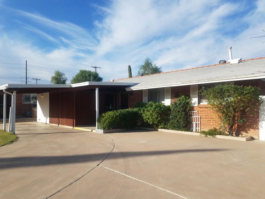 Exceptional Opportunity - 4 bedroom 2 bath Charming Red brick Home.  1 Car Carport with extended driveway for ample parking. Large living room with wood laminate flooring. Screened in Porch/Arizona room off the Dining area. Extra storage and laundry off Kitchen (not included in square footage). Fenced in rear yard.  Lots of Potential- Sold As Is.