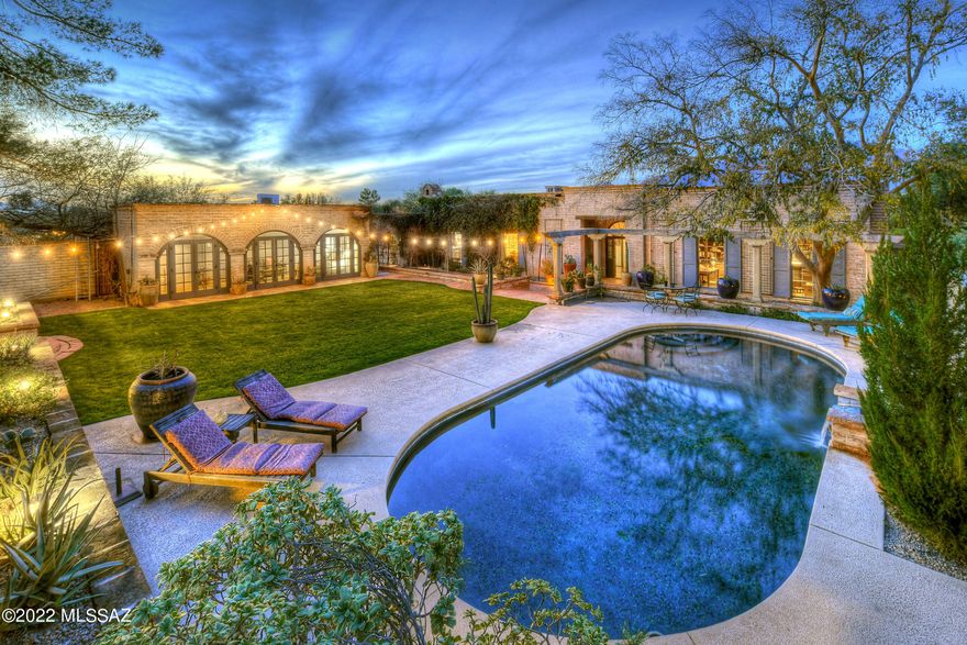 This exquisite property is a rare find! Nestled in Historic Ft Lowell Dist on 1.58ac, this classic burnt adobe home is surrounded by nature and boasts majestic mntn views. Beautiful hand-forged iron gate, brick walkaway leads into a courtyard w/fountain, columned terrace, sparkling pool, patio & grass. Enter the house thru a grand foyer w/high wood beamed ceilings & double doors. Living area w/4374 sq.ft, elegant Great Room w/fireplc, built-in bookcases, walls of picture windows, formal dining rm, gourmet kitchen w/ concrete counters, indoor grill, Wolf and Subzero appliances. Wood beam ceilings, tile & wood flrs thruout, 3 bdrms in main house w/their own baths, master suite w/fireplc, lux bath, lg walk-in closet and priv entry to patio +incredible library, separate guest house w/bathrm.