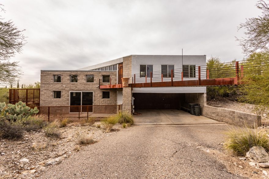 Unique industrial contemporary in the Foothills features block and steel construction. The panoramic view of the city and mountains is a sight to behold from windows that extend from floor to ceiling. This one-of-a-kind home is tucked into the hillside and boasts a large great room, spacious  loft area, and a studio with a private entrance and bath. Don't miss this rare opportunity to add your final touches and customize your dream home.