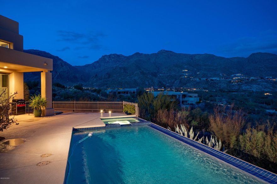 Located at the end of the cul-de-sac overlooking the Ventana Canyon golf course w/ breathtaking 180 degree mountain views, sits this updated 2 story masonry built home in the prestigious (gated) Ridge at Ventana Canyon. The best lot in the subdivision offers views from every window. 3 BR + Office, 3.5 Baths, 2,823 sq ft. Enter through your private courtyard to a large great room w/ floor to ceiling windows & a sleek custom fireplace. Formal dining room perfect for entertaining. Kitchen features granite countertops, double oven, 5 burner stove top, island & spacious eat-in area.  Gorgeous quartz staircase leads to the master suite and 2 additional guest bedrooms each w/ their own bath. Master bedroom w/ balcony & a large master bathroom w/ shower & soaking tub. Professionally designed custom walk- in closet. New dark tiled flooring throughout the first and second floor offers a clean & contemporary design. Resort style backyard w/ infinity edge pool/spa & covered patio to take in the views all year long. New exterior paint, re-surfaced pool, newly re-coated roof & so much more. Updated w/ a balance of modern yet comfortable flair.  This one has it all!