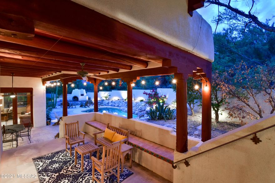 Beautiful Foothills Santa Fe home with southwestern charm on a large private lot. High wood beamed ceilings, with many windows and French doors letting the outside in. The kitchen with granite countertops and stainless steel appliances, also has a large island and plenty of space for today's inspired chef. Abundant living space for everyone and a separate loft area with Catalina Mountain views that is just perfect for your home office. The master suite has doors opening to it's own patio, a large garden tub, updated granite countertops and shower and a huge walk in closet. The private backyard has multiple areas to relax, a water fall trickling into the pool, a fireplace and pizza oven - your own paradise. The garage  is spacious with an extra area of built in shelving for easy storage.