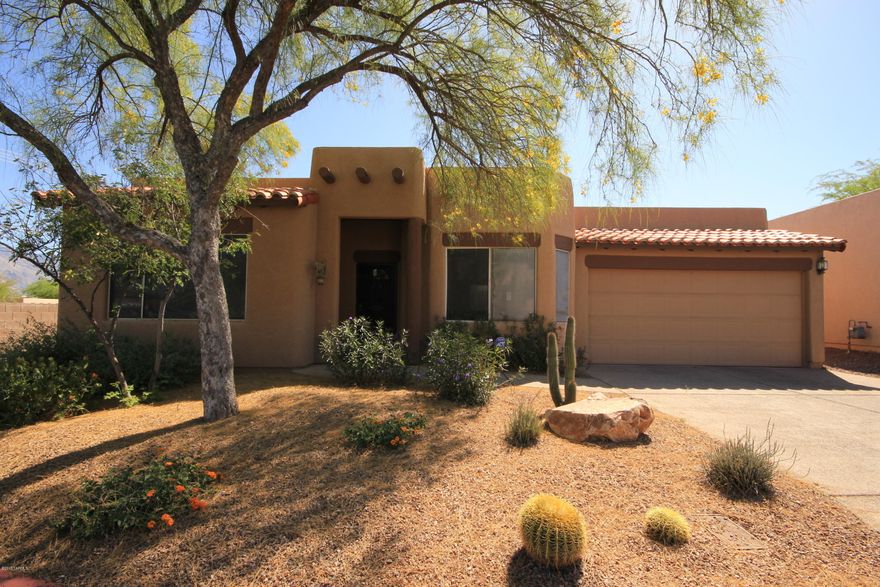 Fantastic location at the end of the subdivision offers beautiful mountain views and privacy. This charming Crest Ranch Home features scored concrete floors throughout and carpet in bedrooms, formal living and dining, open kitchen family room area with fireplace, breakfast nook, kitchen island, roll out shelves and pantry. French doors from Family Room or Master Suite lead to covered patio with pretty low care landscaping and Catalina Mountain views. Ceiling Fans throughout all rooms, Modern High ceilings, wood blinds, skylights, coat and linen closets. All bedrooms feature walk in closets. Master has mountain views, jetted tub, separate shower, dual vanities. Third bedroom has double doors from entry and could be a den. Washer, Dryer, Refrigerator and built in Microwave are included