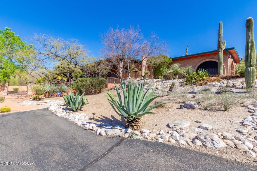 Gorgeous Energy Efficient Solar Hillside Home w/breathtaking Mountain views.  Impressive desert landscape! Soaring ceilings w/wood beams, beautiful tile floors throughout, custom palette, ceiling fans, fireplace for the chilly AZ evenings, built-in bookcases, & formal dining area w/veranda access. Open floor plan, handsome wood interior doors, & Bonus guest house! Center kitchen island, granite counters, breakfast bar, SS appliances, pantry, & plethora of wood cabinets w/hardware. Living room opens to the pool and patio. Private den, generous size bedrooms, ample closets, interior laundry room, & upscale pristine baths. Sparkling pebble tec pool, built-in deck benches, covered patio and bathhouse. Expansive porch with spectacular views of the Catalina mountains. Gorgeous mature landscaping