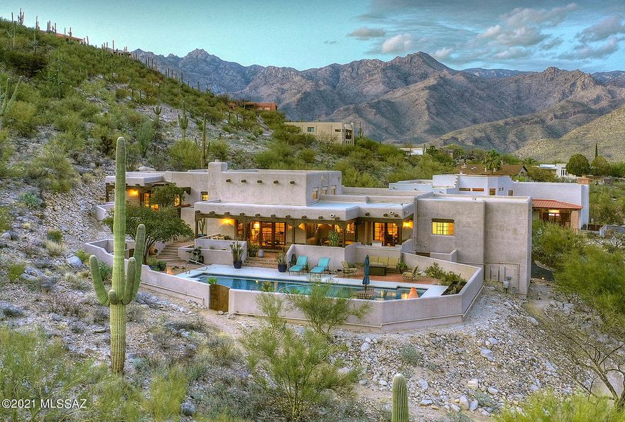 Stunning & sophisticated Santa Fe style home w/magnificent city & mountain views in desirable Foothills  gated community of Rockcliff. Foyer entry w/custom wood front doors, exquisite Greatroom w/dramatic 16ft. High beam ceilings,  French doors, gorgeous fireplace, built in cabinets,wet bar, formal dining room w/built in buffet w/ glass display cabinets & tile countertops, remodeled gourmet  kit w/white cabinets, granite countertops, stainless steel appliances,  gas stove top, SubZero, wine cooler, large pantry, tile & wood floors, (no carpet), 4 BR's + library/study w/built in bookcases, 3 BA's , mstr w/sitting area, lux bath, walk in closet & entry to rear patio. Enjoy resort like bkyd w/incredible 42' x 18' lap pool, cov'd patio, BBQ, lush landscaping, privacy & views from every room!