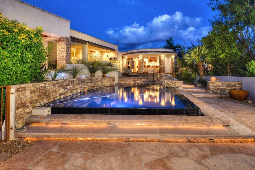 This truly magnificent custom home featuring city, sunset and mountain views boast spectacular finishes throughout and was crafted with the help of Lori Carrol so surely it will please the most discriminating buyer. From the elegantly appointed kitchen with Wolf professional range, Subzero fridge, wine fridge and stunning granite to the amazing outdoors with negative edge pool, spa, firepit, multiple patios and fully equipped commercial grade kitchen/bar, this home is an entertainer's dream. Greatroom offers spectacular views, hand-hewn walnut floors, rustic fireplace, floor to ceiling windows & media area. Luxurious owner's suite with fabulous spa-like bath. Full tech package throughout the home, oversized garage w/lift & compressor plus new exterior paint. This is a must-see home!
