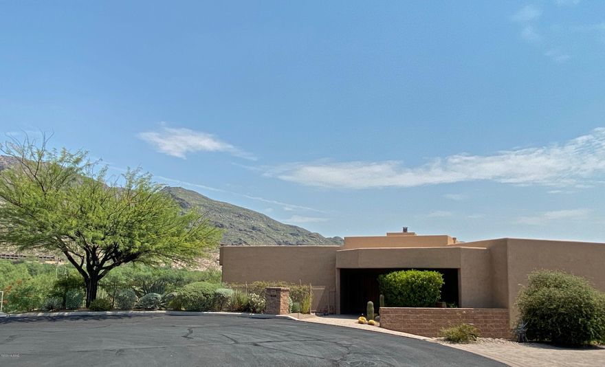 Iconic home in Catalina Foothills with breathtaking views.  Contemporary style home located in gated, private cul-de-sac. Open and light with walls of glass, gourmet kitchen, granite counters, stainless appliances, gas cooktop and walk-in pantry.  Extras include media/game room with sink and refrigerator,  two way fireplace, Master BR built in furniture, Travertine, Select Wood floors throughout. Master Bedroom and main living area are on the same level. Upscale home has top-of-the-line window treatments including rolling shutters on all windows, state-of-the-art Home Automation Control 4 System, surround sound, media components, newer 16 Seer HVAC, brick paver driveway, ''spool'' + water feature, all in immaculate move-in condition.