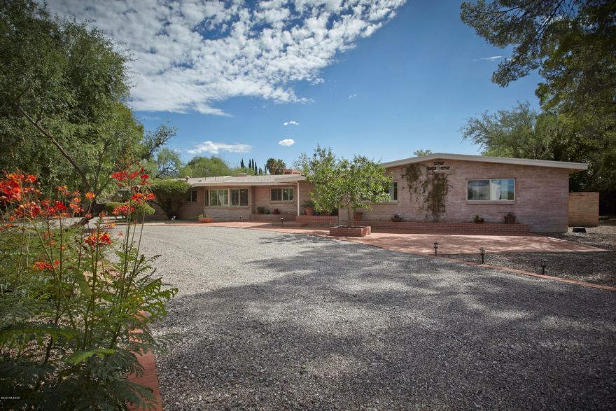 A car collectors dream home in coveted Tucson C.C. Est! This Quintessential TCC home has been recently updated to perfection & has a 5 car garage that will make you the envy of the neighborhood among fellow car aficionados. This 4,065 sq.ft 5BR/4BA home has been updated to reflect the modern day buyer w/a more refined contemporary interior & spacious open floorplan. The gourmet kitchen features a waterfall edge quartz island, stainless appliances & custom cabinets and is open to an adjacent family rm w/stacked stone fireplace & wall of glass doors looking out to the backyard & sparkling pool. The master suite is divine & features a luxurious bathrm & large walk in closet. The large flex space/bonus room is ideal for movie night or a work from home office.  More... The huge backyard w/ expansive brick patios, built in bbq, bocce ball, sport court & fireplace is ideal for social distancing w/the kids or informal entertaining with friends. Updates include Wood plank tile flooring, all new windows, newer mechanicals incl 3 HVAC's & 3 water heaters & newer shingle roof. The Air Conditioned "showroom garage" has brick floors, a workshop area & sink. With the market as hot as the temps outside, this home is priced to SELL!  One owner is licensed to sell Real Estate in AZ.