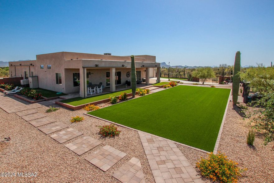 Experience unparalleled luxury in this meticulously crafted custom home, nestled on a sprawling 3-acre estate. Boasting 3 spacious bedrooms and 3.5 elegantly designed bathrooms, this residence offers the ultimate in comfort and style. The Gourmet Kitchen is equipped with top-of-the-line appliances, a dual oven, tile backsplash, abundant cabinets, a generous island and a large walk-in pantry, this kitchen is a chef's dream. The open concept living and dining areas are bathed in natural light, creating an inviting atmosphere for both relaxation and entertainment. 
The backyard features multiple outdoor seating areas that are perfect for enjoying the beautiful Arizona weather and entertaining guests. The property features several majestic saguaro cacti and upgraded faux grass, adding.... to the charm and low-maintenance appeal.
Each bedroom is a private sanctuary with its own ensuite bathroom, ensuring comfort and privacy for all. The primary bedroom boasts a private entry to the backyard, creating a serene oasis. The luxurious primary bathroom features a soaking tub, a separate shower, and ample space for relaxation, as well as a spacious walk-in closet with built-in shelving that provides plenty of storage and organization options. The expansive 3-car garage with extra-long bays is complemented by an additional RV garage, providing ample space for all your vehicles and storage.
Step inside to discover a world of sophistication, with high-end finishes and attention to detail throughout. 
For entertainment, the media room is a true highlight, providing a perfect space for movie nights and gatherings. 
This exceptional property seamlessly blends luxury, functionality, and the beauty of nature, creating a unique sanctuary that you'll be proud to call home.