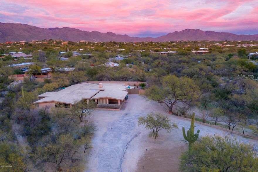 Beautifully maintained single-owner home waiting for your personal touch! First time on the market, this home sits on almost an acre in desirable Tanque Verde Valley, placed nicely off of Harrison Rd. Spacious layout has formal living and dining room plus family room off of kitchen w/ cozy beehive fireplace. Kitchen has ample cabinetry, pantry closet and breakfast bar overlooking the family room. Master bedroom has his/hers closets, dual sinks in the bathroom and private Arizona room. Addition off of family room has den w/ private bathroom, perfect for a home office or guests! Fully enclosed backyard has pool, is well-landscaped with drip system and has exten patio with ceiling fans. Cherry on top is 2 car carport PLUS 2 car garage. Close proximity to Mt Lemmon, hiking trails, & much more!