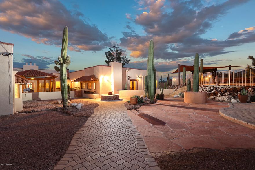 Sprawling Resort Hacienda 5,745 SF 5 BR 7 BA on 6.5 acres. Pictures simply do not tell the story, must be seen in person to truly appreciate the location, views & privacy. Nestled in the Tucson Mountains, enjoy the untouched nature and breath-taking rock formations; your own personal, private, Mountainside get-a-way. Inside, a chef's dream! Gourmet kitchen, granite counter tops, commercial-grade ''Wolf'' stove, ''Earthstone'' pizza oven, spacious island, eat-in nook, formal dining w/ custom granite corner cabinets & arch-way. The attached guest Casita has 2 BR, 2 BA, a Den w FP, kitchen, & wet bar/wine tasting rm! If you love natural stone, you will love this home. A unique Southwestern charm w new ceramic tile, custom int & ext paint & roof w 7 yr warranty. Location is just off Twin Peaks & I-10 interchange for easy access everywhere. Close to Silverbell Park w linked bike trails & sidewalks, Shopping, Twin Peak Outlet Mall, Lehman Academy of Excellence, U of A, & downtown. Total of 6 garage spaces, 3 detached & 3 attached w separate workshop.  Rooftop patio with spiral staircase & office/work-out room. Impressive outdoor features are an entertainer's dream: Multiple outdoor kitchens, grills, patios, decks, beautiful heated/elevated black pearl Pebble Tec pool & spa w/waterfall, creating an unsurpassed outdoor desert oasis. Whether you're looking for a wonderful home & gathering place for friends, a turn-key B and B, or executive rental, the possibilities here are as endless, as the views.