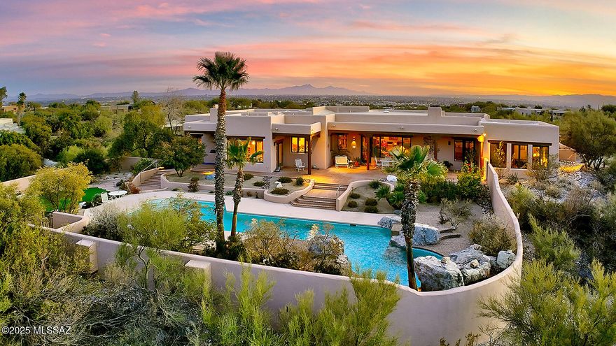 Exceptional Mike Wachs Southwestern-Style Home in Prestigious Catalina Foothills Estates #10.  Nestled within the sought-after, guard-gated Catalina Foothills Estates #10, this stunning 4,948 sq. ft. all-masonry stucco home sits on a rare double lot spanning 2.89 acres. Designed to embrace breathtaking, unobstructed views of the Catalina Mountain   and iconic Finger Rock, this five-bedroom plus den retreat offers the perfect blend of luxury, character, and timeless Southwestern charm.  Perched high on a hill, a circular driveway leads to an inviting courtyard entry, complete with a covered patio and captivating city views. A grand 4-inch-thick oak front door welcomes you into the spectacular great room, featuring Saltillo tile floors, viga-beamed and cedar strip ceilings with corbels an expansive display bookshelf, charming beehive fireplace, walls of windows, and a mud adobe bar area, all thoughtfully designed to maximize the striking mountain backdrop. An adjacent formal dining room provides a charming space for entertaining.  The warm and inviting Southwestern-style kitchen boasts a spacious center island, ample cabinetry, Talavera countertops, and a bright breakfast area. The gracious primary suite includes a cozy seating area, a beehive fireplace with a niche, a walk-in closet, dual vanities, and direct access to the backyard.  A generous 1,491 sq. ft. three-car garage with an RV bay provides abundant walk-in storage rooms. Outside, the park-like backyard is a true oasis, featuring an expansive rear porch, a lap pool with a waterfall, an artificial turf area, and stunning panoramic mountain views.  This quality-built home is a masterpiece of craftsmanship, brimming with charm and character at every turn. A must-see to fully appreciate!