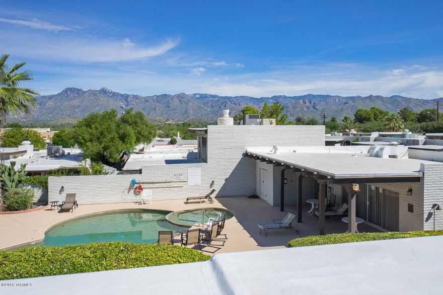 Impressive Townhouse in Convenient Northeast location, close to Restaurants, Shops, Bus Lines and Udall Park. Panoramic Mountain Views from Rooftop Sky Deck overlooking Community Pool and Club House.   Stunning Front Elevation, Deep Setback, Spacious Driveway and Private Courtyard Entry.  Contemporary Floor Plan and a Clean, Fresh Interior.  Big Windows and Glass Sliders for that Indoor-Outdoor Connection we Love!  Upstairs Master Suite with Balcony; Guest Bedroom & Bathroom on Main Level.  Cool, Modern, Lovingly Maintained and Move-in Ready.