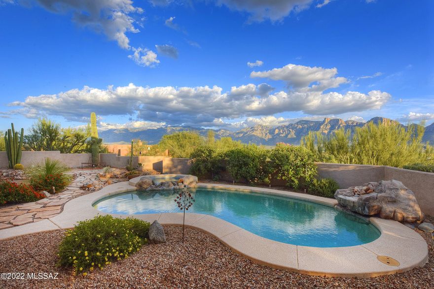 Lowest priced home in Coyote Ridge! This property is an incredible value, with a very motivated seller. Panoramic mountain views & pristine natural desert surroundings make this custom Coyote Ridge home a tranquil retreat! Enjoy the homes FULLY OWNED SOLAR ENERGY SYSTEM for MINIMAL ELECTRIC BILLS! Peaceful, private gated courtyard with an outdoor fireplace. Embrace the home's fine craftsmanship and finishes: travertine tile, soaring ceilings, and an abundance of large windows for great natural light and phenomenal mountain views. The open, stylish kitchen offers a KitchenAid Gourmet-Kitchen Package with a stainless-steel gas cooktop and touchless kitchen faucet, double wall ovens, custom cabinetry, built-in wine rack, large island, prep sink, trash compactor & extensive breakfast bar... Retreat to the luxurious master bedroom and enjoy a soak in the spacious jetted tub or a quick shower with double shower heads! Enjoy the home's three additional spacious guest rooms with the fourth bedroom offering a private entrance to and from the pool. This home offers plenty of closet space/storage to make up the well-planned layout. High ceilings throughout, including 15-ft ceilings in 3 rooms. The backyard is perfectly landscaped and features a large pool + spa with 2 water features, built-in BBQ, extended patio and immediate, private access to a walking/biking trail. This home is Move-In ready with freshly painted walls! Nestled in the heart of Oro Valley, this beautiful home is less than 5 minutes from shopping, dining and more!