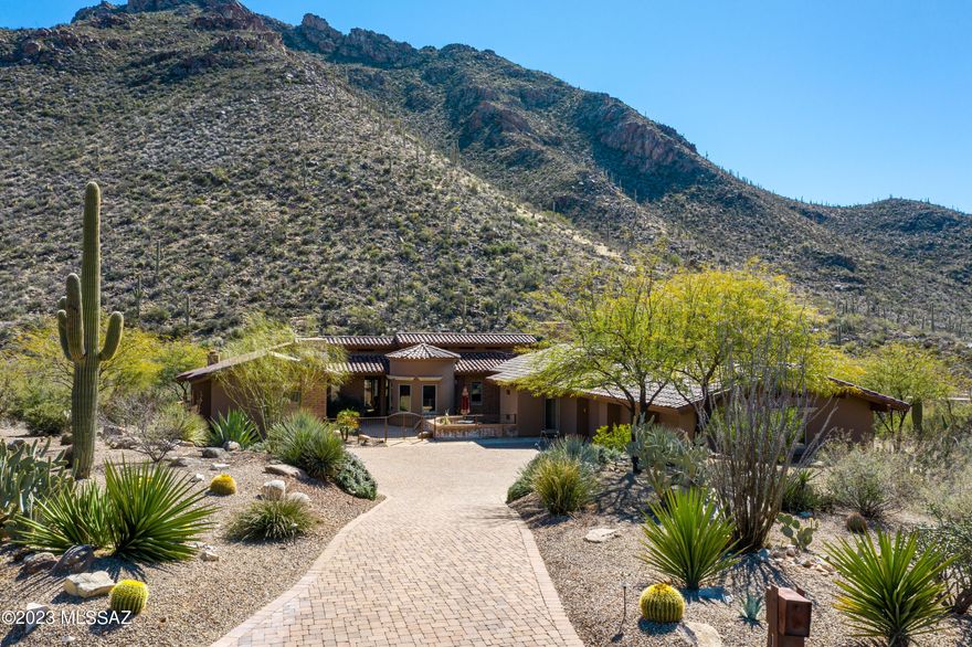 Mesmerizing saguaro studded mountain views from this elegant stunning custom home nestled on a very private  lot in gorgeous Canyon Pass at Dove Mountain. Exquisite fine features include rich wood beam ceilings, sprawling gourmet kitchen w/stainless steel appliances,  elongated island, unique granite countertops, rich/gorgeous stained concrete floors, abundant custom woodworking just to name a few. Remodeled pool & spa with expansive outdoor living areas including new fireplace w/raised planter box. Pool  upgrades include: newer pool/spa heater, upgraded  AquaLink controller system, variable speed drive motor. Relaxing master bedroom w/sauna shower & soaking tub.Expansive, oversized 3 car garage w/storage. 4 bedrooms or 3 bedrooms + office/den.  Dual master bedrooms - both w/fireplaces.