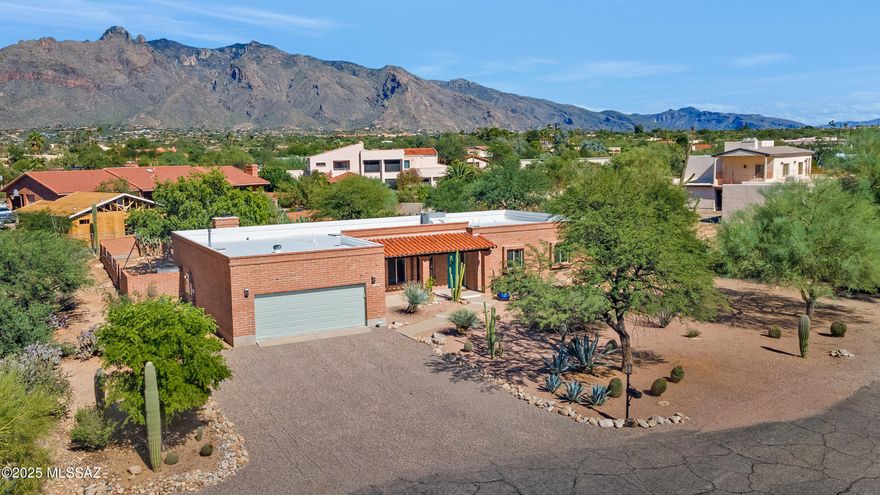Price Reduced!! Truly special Burnt Adobe Southwestern Territorial home located in highly coveted Shadow Hills in the Catalina Foothills. Terrific mountain view, North facing rear yard on a cul-de-sac lot. Deeply loved, meticulously maintained, recently updated and upgraded kitchen, flooring and bathrooms. Modern cabinetry, counter tops and appliances enhance the chef's experience in the kitchen which is open to the family room with warm fireplace, making family dinners or entertaining more enjoyable. Entry foyer welcomes all to a versatile living room that could serve many purposes, the good-sized dining room is another flexible space to enjoy. The large primary suite leads to wonderfully upgraded primary bathroom which features a double vanity, plenty of storage, large walk-in shower and closet.
The resort style rear yard boasts a fabulous heated pool, separate grassy area, multiple play places and specimen plantings. Large covered patio, fire pit and mountain views add to the wonderful space. Roof and windows recently updated and adobe recently sealed.