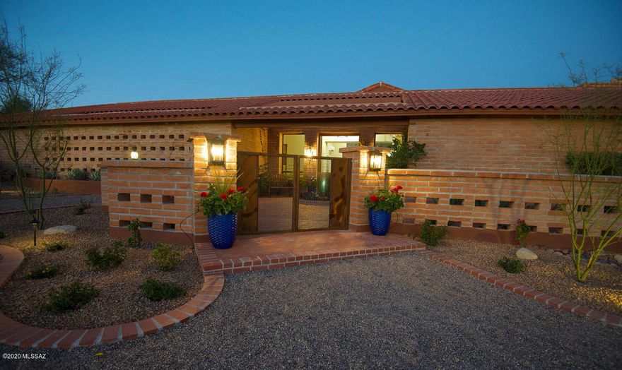 Accepting backup offers. Lots of WOW! Beautifully updated home. The front gated courtyard welcomes you with a lighted fountain and lush landscaping. Open the 10 foot high metal clad front doors and enter into the newly added living room with 14 foot high ceilings and dramatic wall of custom Pella windows framing a breathtaking double saguaro with mountain backdrop. Travertine floors & showers. Gourmet kitchen w/live-edged granite counters. SS appliances, gas cooktop, new Bosch microwave drawer & dishwasher, dbl oven, wine refrigerator, washer and steam dryer. Updated bathrooms, jetted master tub, jetted master shower panel. Large backyard w/Pebbletec pool, dbl saguaro, mtn view. Private covered master bedroom patio and a covered BBQ patio. Split bedroom plan. N/S facing. Owner/agent