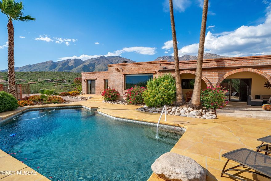 Located on a high view lot in Cimarron Foothills Estates, this classic, one-level burnt adobe home is completely remodeled & meticulously maintained. Panoramic mountain, city & sunset views from this very private near 1-acre lot.  Circular driveway lined in pavers complimented by low-care desert landscape. Bright & open split bedroom floor plan w/ travertine floors throughout (no carpet). Upon entry find the living room w/ spacious formal dining area. Updated kitchen w/ custom cabinets, granite counters & SS appliances opens to great room w/ high wood-beam ceilings & FP. Breakfast bar & breakfast nook provide informal dining.  Large pantry, bonus area w/ built-in desk & spacious laundry room. Exceptional deep covered patio off kitchen is perfect for entertaining groups lrg & small. CONT Spacious Owner Suite w/ Bee-Hive Fireplace & Charming Sitting Area w/ Beautiful Natural Light. Owner Suite Bathroom is Completely Remodeled w/ Dual Vanities, Custom Cabinets, Granite Counters, Clawfoot Tub & Separate Shower w/ Travertine Surround.  The 2 Additional Full Bathrooms are Updated Similar to Owner Suite Bath. 2 Additional Bedrooms both have Sliding Glass Doors to the Patio. Exceptional Backyard w/ Resurfaced Pool & Pool Deck, New Brick Paver Patio, New Pergola w/ Outdoor Kitchen that includes a Built-in BBQ & Refrigerator. 2- car Attached Garage & Oversized 2-car detached garage/workshop w/ wall AC Unit. This Extra Space Could be used in so Many Ways-Extra Storage, Workout Space, Art/Ceramics Studio or Whatever You May Need. Additional recently added features of this home include Plantation Shutters, Double Cherry Wood Front Doors, Irrigation System, Gutters, Soft Water System, Water Heater & Pool Pump, Filter and Motor.  District #16 Schools including Ventana Vista Elementary w/ Highly-Acclaimed Spanish Immersion Program. Incredible Foothills Location within Minutes of the Best Shopping & Restaurants Tucson has to Offer.  Close to World-Class Golf Resorts & Country Clubs and Tons of Hiking & Biking Trails including Sabino Canyon. This home is truly immaculate.