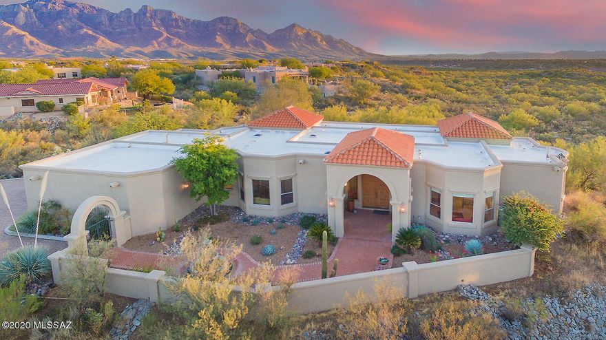 Striking 4BD/3BA (3,045 sq ft) estate on premium view lot in gated Estates at High Mesa boasts panoramic mountain/sunset/city light views! Charming, gated courtyard w/tiered fountain flows to an inviting living/dining room w/soaring ceiling. Beyond lies a Great room w/stacked stone fireplace & beamed ceiling. Updated gourmet kitchen showcases high-end appliances, granite leather-look counters, center island, breakfast nook & wine bar. Master suite w/patio access hosts a fireplace and luxury bath. Private guest suite w/bath & patio; front bedroom overlooking courtyard; plus office/4th bdrm. Fabulous rear oasis boasts a heated pool/spa, citrus trees & grill station. Decorator colors, bay windows, skylights, coffered ceilings and brick paver patios add to the ambiance of this serene setting.