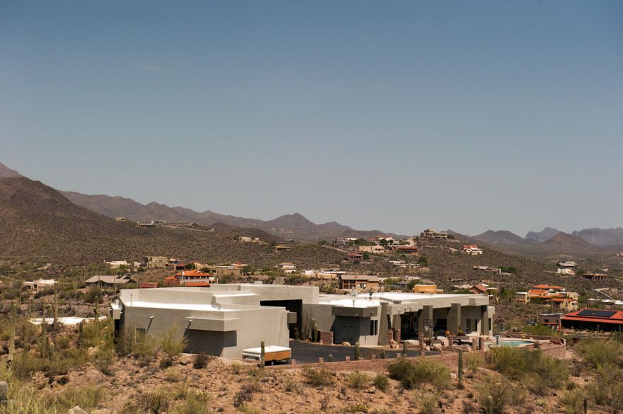 Custom built home in the foothills of the Tucson Mountains on 5 acres. Spectacular views of the city and the Mountains. Private drive to the house is lined with an abundance of saguaro cactus. The driveway enters the property through a breezeway, which opens up to a spacious auto court for plenty of parking for your guests and RV. Open floor plan and multiple bedrooms with adjoining bathrooms so you do not have to share. Huge 6-car garage with a workout room, indoor parking for all your toys, storage for Holiday decorations, air conditioned and heated for all year use.  Easy access to I-10. Huge covered back porch for out door living and just relaxing while enjoying the view of the city coming alive at night. This house is a must if you have a large family and like to play hard and relax. Great views from the pool and spa, you will never want to get out. If you do not say "Wow "the moment you drive into the auto court then this house is not for you.