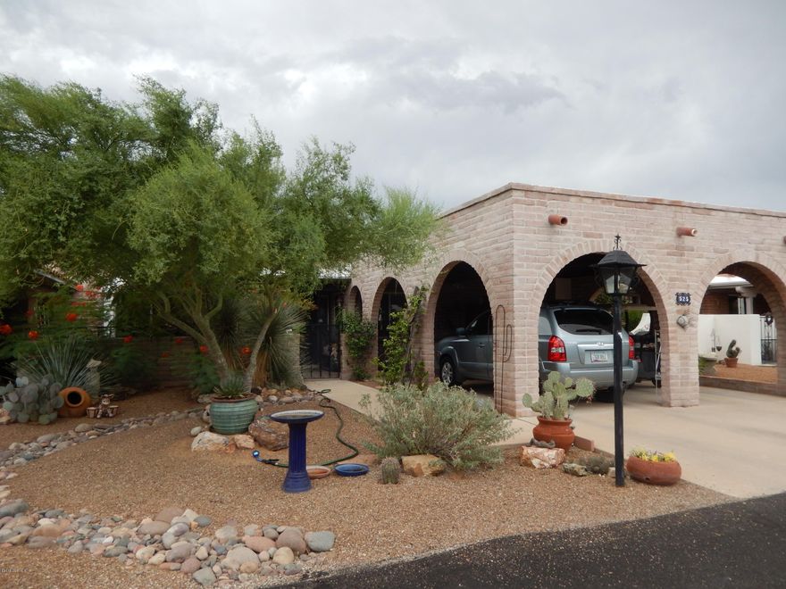 You've found your Oasis in the desert! Enjoy the lush setting and updated conveniences. 2 Bedroom suites, 2 Baths, plus den/family room, large living room, & screened back porch. Cozy gas beehive fireplace and lovely tile floors. The kitchen boasts stainless appliances, corian counters, and glass tile backsplash. Built-in cabinets with desk, extra hall storage and carport cabinets. Other features include roller shutters, pull out shelves, & 14 seer AC. Extra long 2-car carport but could make house dark if converted to garage. Some furniture available by SBOS