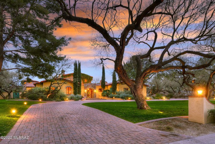 Presenting ''CASA DE ORO'' — This spectacular ''Old World'' Spanish Colonial-style masterpiece is nestled in guard-gated Tucson Country Club Estates and backs up to the 7th fairway of the golf course.  This stunning 5,414 sq. ft. home, built by Perry Mele, features curated materials imported from San Miguel de Allende and Oaxaca. Highlights include lush grounds with grass and majestic mesquite trees, hacienda-style courtyard entry with surrounding covered walkways, charming fountain and painted doors by artist Judy Perry.  Enter the main residence through vintage wooden ''speakeasy-style'' double doors into the great room featuring soaring 25' cathedral beamed ceiling, teak flooring, a grand gas/wood fireplace, "Tree of Life" hand-carved door, a full wet bar with refrigerator & 2 wine coolers, formal dining area, and hidden stairway leading to the 538 sq. ft. mezzanine/office.  Walk out of the mezzanine through double doors to the large roof-top terrace overlooking the golf course with sunrise and mountain views. The "pope's balcony" is perfect for sunset viewing.  Leading from the great room to the kitchen/family room is the butler's pantry, offering distressed cabinetry and glass doors. The fabulous gourmet island kitchen provides recessed Viking stove with stone surround, a wood-paneled refrigerator, double farm sink and arched ceiling. The family room, open to the kitchen, features teak wood flooring, cozy gas/wood fireplace, beamed ceiling, light & bright breakfast nook with high domed ceiling plus double-doors leading to the covered back patio with golf course views. The comfortable library/office/4th bedroom offers generous built-in bookcases, a charming gas/wood fireplace and an office alcove. From the great room to the master suite is the transition room (separating the public from the private areas) offering a vaulted ceiling with chandelier. The gracious master suite features scored concrete flooring, a coved beamed ceiling, a cozy gas/wood fireplace, 2 walk-in closets, and a sitting area. The luxurious en-suite master bathroom offers Mexican tile accents, dual vanities, a claw-foot tub in the circular "tub room", a steam shower, and a separate exercise room/office.  Bedroom 2 and 3 both provide en-suite baths. Bedroom 3 is perfect as guest quarters featuring a separate entrance off the courtyard plus a large closet with a small fridge & microwave. Walk out of the great room through double doors onto the 56' x 13' covered back patio complete with an outdoor gas/wood fireplace, ceiling fans, two chandeliers and brick flooring. Enjoy the beautiful backyard offering a generous grass area with mature mesquites, all backing up to the golf course.  Additional features include a vegetable garden, fruit trees, 3-car garage and an over-parking area.  Words and photos do not describe this residential masterpiece... see to appreciate!