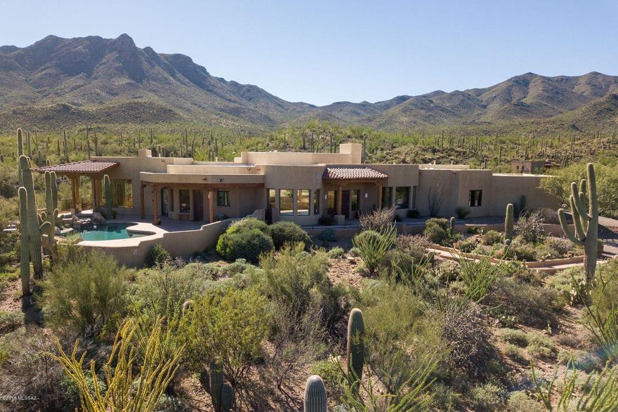 This pueblo style home is located on a secluded 3.69-acre lot which is rich with true southern Arizona beauty. Stepping into your new home will have you awestruck as you peer through the massive window which will give you your own majestic mountain view. Entertaining will be a breeze in this 3,810 square foot home with your built-in bar and eye-catching fireplace. This open floor plan will give quick access to the granite countertops in your kitchen which is equipped with stainless steel appliances and a five-burner gas range. You will have a desert oasis with a hot tub flowing over a waterfall into your pool where you can boast some of the finest views. Take a quiet evening in, sitting next to your second fireplace in your master bedroom which has an enormous walk-in closet and luxurious master bathroom. There are three
additional bedrooms, all with views, two of which having their own porch to take in those famous Arizona sunsets. This is a must-see home.