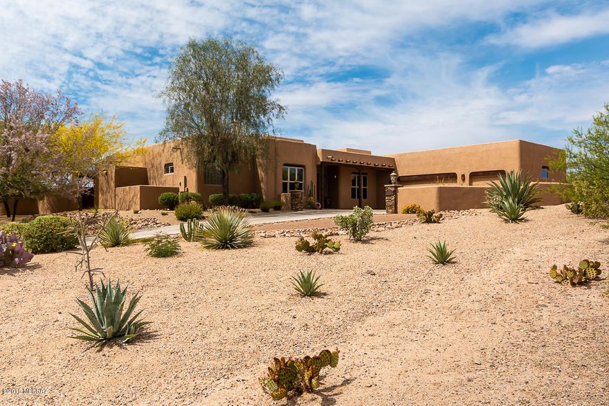 Stunning view home on a private elevated lot with incredible mountain & sparkling city views. Home offers 3,476 sqft, 4-BR/4-BA, office, & 3-car garage on more than an acre. Enter this gorgeous house & feel the excitement of the grand great room with beautiful viga wood-beamed ceilings & captivating views. Features include tile flooring throughout, solid alder doors & cabinetry, architectural niches, high ceilings, 2 fireplaces & designer fixtures. Gourmet kitchen w/custom cabinetry, SS appliances & granite counters. Sensational resort-style backyard designed by architect Joe Prchal is a breathtaking private paradise w/an amazing pool, travertine tile, gas fire pit & a spacious shady patio. Perfectly located in southern Oro Valley, close to shops & restaurants, with easy access to I-10.
