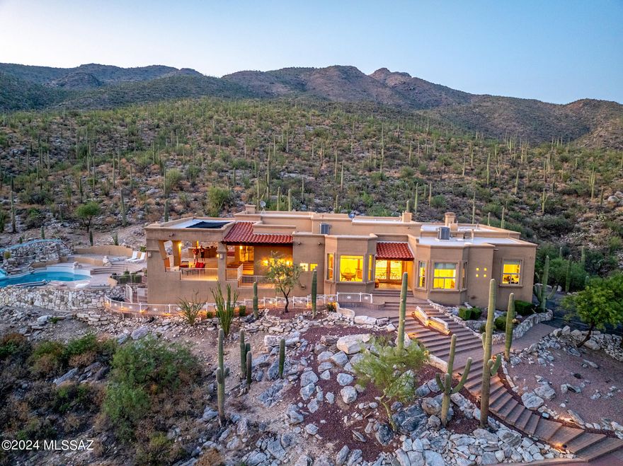 Nestled in the prestigious Tanque Verde Valley, this extraordinary home offers a harmonious blend of luxury, comfort & natural beauty.Surrounded by an abundance of towering saguaro cacti and framed by breathtaking multiple mountain views, a sanctuary of serenity & sophistication. From its elegant design to its premium amenities, every aspect of this property has been meticulously crafted to provide an unparrelleled living experience. Arrive to stricking metal front door welcomes you into a world of tranquility. Step inside and be captivated by the scenic vistas that greet you from every window, seemlessly blending the indoors with the magnificient outdoors. Many recent upgrades; New HVAC 2022, New Windows 2019, New Water Softner, Water Filter, Solar for pool, new pool heater added 2019. The outdoor oasis is the luxurious pool area.Dive into sparkling pool complete with a slide, spa and rock formation, all heated by efficient solar power.  The wrap around covered patio offers perfect space for entertaining, with city lights and mountain views. Family rm is located off kitchen with f/p. Chef's Kitchen with center island, breakfast bar & breakfast nook. Dining room windows frame city lights. Primary suite with gas f/p, patio, primary bath with jetted tub, custom closet, glass block shower. Living room with stacked stone f/p, vigas, corbels & wood beams. Oversized secondary bdrms with jack/jill bath. 3rd bath with jetted tub. Whole house water filtration. A WOW home!!!