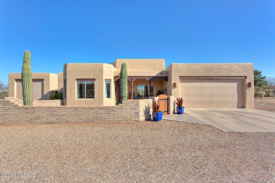 Fabulous Santa Fe style home on over 1 acre with gorgeous mountain views. Home is set back for privacy galore...plenty of room for a pool. Features include a 40' x 20' RV GARAGE, plus an extended attached 2 car garage with workspace. Remodeled kitchen and bathrooms.  Living room with gas fireplace & viga beams on the soaring ceiling. One of the bedrooms and full bathrooms includes a door to the entrance, making it ideal for a guest suite. Nice front courtyard with fountain and large back patio. Central vac, ceiling fans, storage sheds and all appliances are included! Situated in the highly desirable community of Rancho Buena Vista, with low HOA dues and close to shopping & I-19 access.  Call for more details and to schedule a showing. Beautiful home!