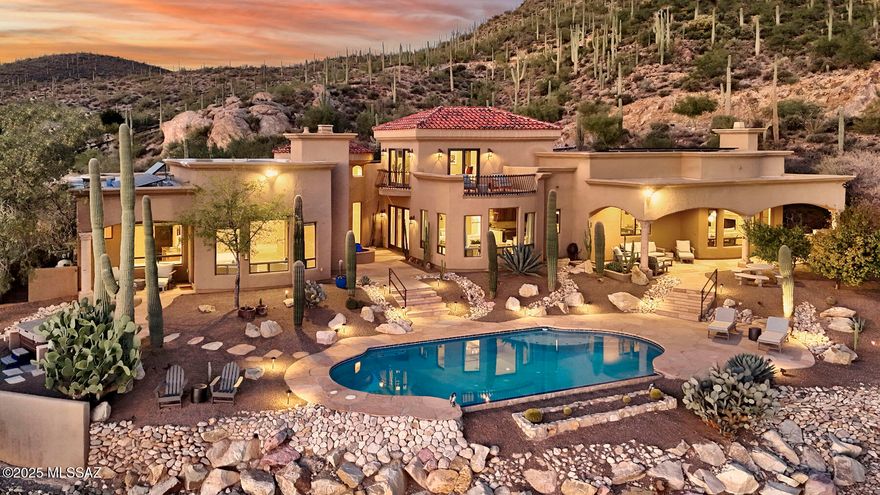 Unmatched Tucson elegance in a prestigious, gated community — The Estates at Starr Pass — high above the city in the Tucson Mountains. Set at the base of Saguaro National Park, this exceptional 4,995 sq. ft. luxury residence sits on 3.3 acres of pristine, saguaro-studded desert, offering unparalleled privacy and sweeping views of Tucson's skyline and mountain ranges.  Blending modern Southwest design with elegant contemporary functionality, this home exudes warmth, sophistication, and comfort.  Step inside to discover soaring ceilings, expansive living spaces, walls of glass, and an open floor plan ideal for entertaining. The dramatic foyer is the center of the home. Just off the foyer, the spacious living room features a formal dining area, and a coffee bar/wet bar combo, providing inviting spaces to relax or host with style. The comfortable family room, open to the kitchen, offers a cantera fireplace, numerous built-ins, and a light & bright breakfast area. The gourmet chef's kitchen is the heart of the home, featuring custom cabinetry, granite countertops, a large island with a prep sink, and top-tier stainless steel appliances including a professional-grade range with a pot filler and double dishwashers. The split floor plan ensures privacy, offering four spacious bedrooms, each with its own en-suite bath.  The primary suite is a serene retreat with stunning views, a fireplace, access to a private covered patio with a hot tub, a spa-inspired bathroom with dual vanities, and a generous walk-in closet. The office features custom cabinetry, and the adjacent den/office could be a 5th bedroom.  Upstairs, an impressive guest suite offers a private balcony with panoramic views, perfect for visitors or extended family.  Step outdoors to your resort-style backyard, complete with covered patios, extensive use of flagstone pavers, a sparkling pool, and a built-in BBQ, all framed by Tucson's spectacular sunrises & sunsets.  Every luxury detail has been considered, including fully owned solar, whole-home water softener, reverse osmosis system, automatic window coverings, and gas fireplaces throughout. The three-car garage provides ample room for vehicles and storage, including a mud room.  Located just minutes from downtown Tucson, you'll enjoy quick access to fine dining, shopping, and entertainment. Hiking trails begin just beyond your doorstep, and Starr Pass Golf Club is a short golf cart ride away.  Experience the perfect balance of secluded desert living and urban convenience in this truly extraordinary home.  Schedule your private tour today and discover the best of Tucson luxury living!