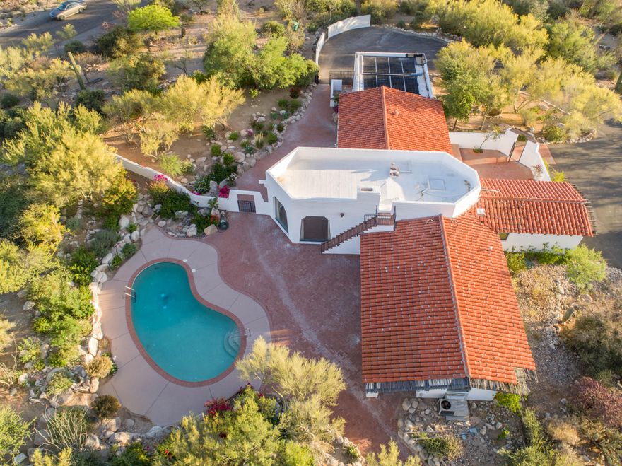 If you are looking for charm-this is it. The best lot in the foothills with almost 9 acres of land. Amazing 360*views. solar heated pebble tech pool,rooftop observation deck.Amazing landscaping includes rose gardens w/extra lighting &plenty of mature fruit trees w/ a 5 valve irrigation system & extra water access throughout property. Gated front courtyard w/brick pavers. Spectacular great room w/high ceiling, wood beams, Grand fireplace w/a beautiful mantel acquired from Mt. Lemmon.  Walls of glass surround the great room to capture the beautiful views! Home includes motion detector security system, central vacuum &concrete flooring. Two on demand heaters,newer A/C Zoned unit. The outside of the home is incredible with multiple walking paths,and well manicured landscaping. You will love it