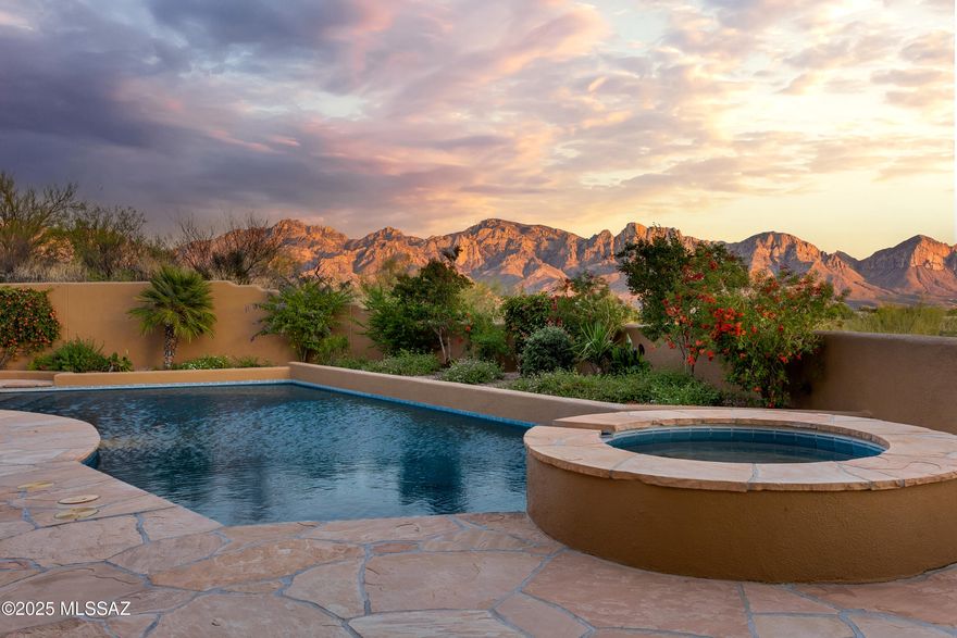 Exceptional southwestern-style custom home with panoramic mountain views in the Estates at Honey Bee Ridge, a guard-gated community in the picturesque Tortolita Mountains in the town of Oro Valley. This elevated, former Street of Dreams homesite offers commanding views of the Pusch Ridge, sparkling city lights, and breathtaking Arizona sunsets. A gentle climb up the paver-lined driveway leads to a spacious motor court with ample guest parking. This sanctuary-style home begins with a charming brick walkway lined with vibrant desert landscaping and the scent of jasmine in the air, which leads to a large, enclosed courtyard shaded by mature mesquite trees. This impeccably maintained home is filled with warmth, character, and architectural detail. Soaring wood-beamed ceilings and a wall of windows frame the stunning Catalina Mountains, immediately connecting the indoors with the surrounding natural beauty. The Saltillo tile floors throughout the home, with no carpet, are complemented by custom wood cabinets, built-ins, and natural stone elements.
The heart of the home is the beautifully renovated kitchen, which was updated in 2023. It features custom cabinetry, quartz countertops, a center island, and stainless steel appliances, including a gas cooktop with a copper-covered hood. Floor-to-ceiling windows surround the adjacent breakfast nook. A custom copper bar area, located next to the wet bar with sink and wine refrigerator, adds convenience for entertaining.
The open kitchen seamlessly flows into the great room, featuring a gas fireplace, and offers spectacular mountain views through large picture windows. The formal dining room, located just off the kitchen, is ideal for hosting gatherings. A powder room nearby provides added convenience for guests. Designed for easy living, whether you are entertaining guests or enjoying a quiet evening at home. 
This single-level, four-bedroom, four-bath home offers a split-bedroom floor plan with two spacious primary suites. The main suite is a luxurious retreat, complete with a sitting area and fireplace, direct access to the backyard, a spa-like bathroom with dual vanities, jetted tub, separate shower, and a large walk-in closet with custom built-ins. The junior suite, also featuring exterior access, includes a full bathroom with convenient access to the pool.




Enjoy the Arizona weather with the wraparound covered patio, offering multiple seating areas, a built-in gas fireplace, and a fully equipped outdoor kitchen featuring a built-in BBQ, sink, and refrigerator. The resort-style backyard features flagstone decking, a pool and spa, and lush, thoughtfully designed landscaping. Elevated for privacy and unparalleled views, this property is a true desert sanctuary.

The Estates at Honey Bee Ridge, located in Honey Bee Canyon, is characterized by the unique rock outcroppings in the area, as well as ancient petroglyphs found on the nearby hiking trails. This guard-gated neighborhood consists of custom homes on large lots only; there are no townhomes or condos. 
Oro Valley, recently rated the "Safest and Wealthiest Retirement Community" by gobankrates.com ahead of Prescott, Scottsdale, Rancho Palos Verdes, Laguna Woods, Walnut Creek, La Quinta, Seal Beach, Rancho Mirage, Palm Desert, Palm Springs, and many more. 
Golf: The Stone Canyon Club is right around the corner from the Estates at Honey Bee Ridge. Stone Canyon is a hidden gem nestled against the picturesque Tortolita Mountains in the town of Oro Valley, just northwest of Tucson, Arizona. This private golf community boasts over 1,400 acres of breathtaking land and is highlighted by a Jay Morrish designed world-class golf course. Stone Canyon is the only golf course in the greater Tucson area to have been ranked in the top 100 golf courses in America by Golf Digest. Accompanied by a luxurious Health & Fitness facility and a modern restaurant, Stone Canyon leaves no stone unturned in providing you with all the comforts one could desire. Enjoy our many golf, social, and fitness events hosted consistently throughout the year.
Tennis and Pickleball: Both public and private tennis and pickleball courts are everywhere you go in Oro Valley. The beautiful Arizona weather attracts visitors from all over the country and the globe who come here to play tennis and pickleball. 
Hiking: This home is located less than 10 minutes from  Catalina State Park. Catalina State Park sits at the base of the majestic Santa Catalina Mountains. The 5,500 acres of foothills, canyons, and streams invite camping, picnicking, and bird watching. The park offers miles of equestrian, birding, hiking, and biking trails that wind through the park and into the Coronado National Forest.

Biking: The Loop is a system of 138 miles of paved, shared-use paths and short segments of buffered bike lanes connecting the greater Tucson area.  One of the best locations to connect to the loop is in Oro Valley.  The most popular starting point is the centrally located Rillito River section of The Loop, located on the 4500 block of North First Avenue. This portion of The Loop has the most "things to do" including restaurants, parks, robust shopping, bars, and more..