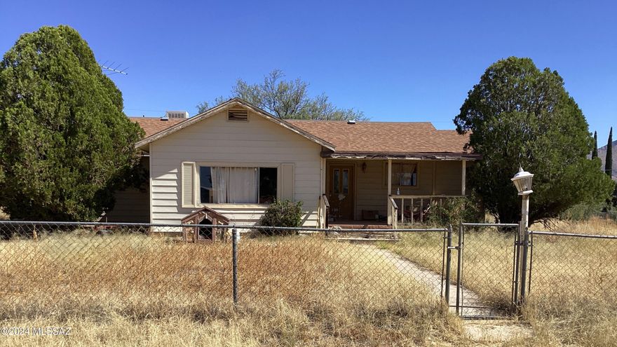 This is a 1564' 2-bedroom, 2-bath with den fixer-upper that sits on a .38-acre corner lot & is being sold ''As Is''.  Nice front covered porch leads you into the spacious foyer, living room, dining & a pass-through window to the kitchen. The den is off the kitchen & has a split bedroom plan. Primary has its own sitting area, bathroom, walk-in closet, dressing room & access to the backyard. On the opposite end is a bedroom, guest bath & laundry room with back door. There is an existing shed & out-building on the property & room for RV Parking through the double gate in the chain link fence that is completely around the entire property.  This house is ready for its new vision to be put into reality and become someone's home. Come on out & see for yourself what this property has to offer.