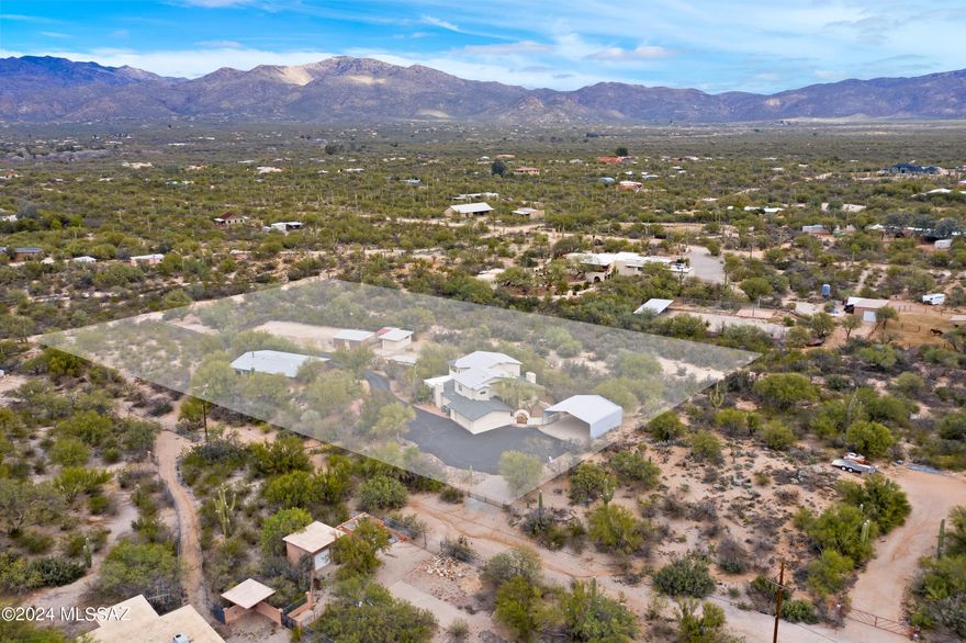 Two homes on 3.6 acres nestled at the base of Saguaro National Park East in ''the notch''. Horse property with majestic views of Catalina Mountains. 2926 sq ft main house features 4BR/3.5BA/2 Car garage, wood beam ceilings, kitchen with maple wood cabinetry, granite counters, built in desk. 2 Fireplaces, large master suite with entrance onto view deck. Perfect for outdoor entertaining. Flagstone patio, firepit, seating areas. Separately metered 2BR/1BA 1199 sq ft detached private guest house w/4 car tandem garage. Approx 30' x 30' covered RV shelter, 60 x 150 arena with predator proof fencing. Large backroom, 3 covered stalls, 12 x 20 workshop (1 car garage), covered hay storage. 2 blocks tp dog friendly trail in Saguaro National Park . Set back from 5th street for peace and quiet.