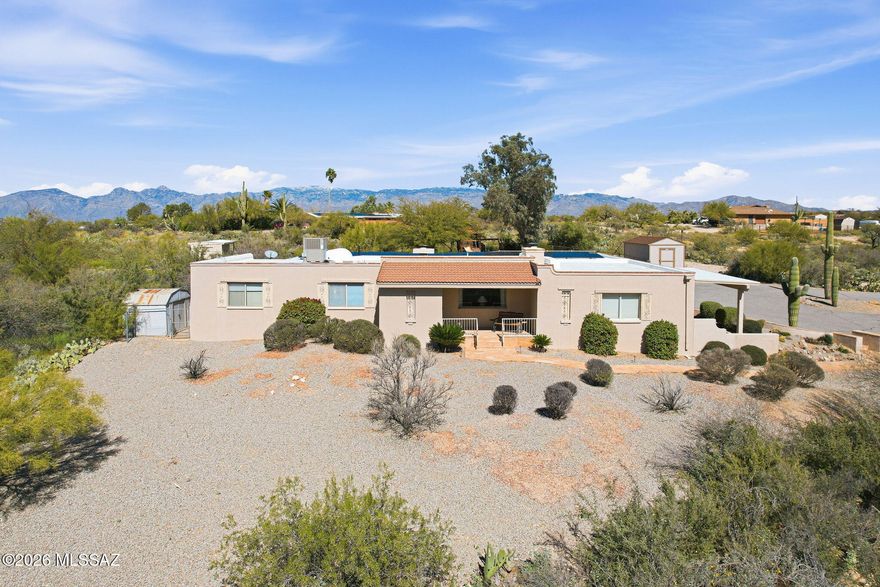 Escape to your own desert paradise on an expansive 3.4 acre estate. A flagstone walkway welcomes you through the entry to the comfortable living room, with fireplace! Generous dining room offers intimate space or plenty of room to expand for your holiday feast, with crackling fire place! The modern kitchen features a breakfast bar, buffet, stainless steel appliances and granite counters.
The primary bedroom features a remodeled bath & opens to a private covered patio for relaxation.
Enjoy 2 additional bedrooms & a double vanity guest bath. Party sized family room, perfect for game day & movie nights! Sparkling diving  pool with dramatic views! Reap the savings benefits of the owned solar system! 10 x16 tuff shed to convey with the property. Tack room, metal shed & playset convey as-is.