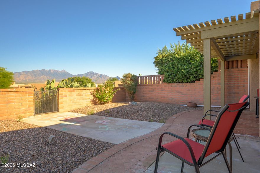 Welcome to a beautifully modernized townhouse designed for the active retiree seeking comfort, convenience, and breathtaking mountain views. Step inside to discover rich southwest-inspired diagonal tile flooring that flows gracefully throughout the entire home.  Impressive 12-foot ceilings, clerestory windows, and strategically placed skylights fill the home with abundant natural light, creating a warm and inviting atmosphere.  The stunning, fully updated kitchen is a chef's delight, featuring attractive hickory cabinets, granite countertops, and new stainless-steel appliances. You'll enjoy the views from the cozy dining area.  An elegant archway seamlessly connects the kitchen to the living area, encouraging conversation and gatherings with friends and family.  Retreat to a spacious primary suite large enough for a cozy sitting area and enjoy private access to your own secluded patio--perfect for morning coffee or quiet evening retreat. The versatile guest bedroom, equipped with a Murphy bed, easily transforms into an office, den, or creative space to suit your lifestyle needs.  Step outside to your east-facing patio, crafted with a low-maintenance aluminum ramada, where unobstructed Santa Rita Mountain views await. Start your days with breathtaking sunrises and unwind each evening as vibrant desert sunsets paint the sky with unique colors each evening. Nestled in a gated community, you'll enjoy a private pool exclusively for residents and full access to Green Valley Recreation's exceptional amenities.  This is an ideal Southern Arizona townhome for those ready to have a special winter get away or embrace an active and vibrant retirement.