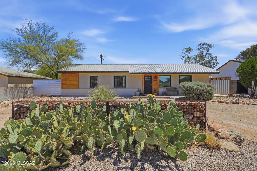 Tastefully updated mid-century home in the heart of Central Tucson! This inviting property features an open floor plan with luxury vinyl flooring throughout, creating a bright and functional living space. A custom kitchen offers an island with breakfast bar seating, oak and quartz countertops, farmhouse sink, stainless steel appliances, and stylish two-tone lighting. Dual-pane windows enhance energy efficiency. Beautifully updated bathrooms feature both oak and quartz countertops, custom medicine cabinets, and vessel sinks. Topped with a durable metal roof, this spacious lot includes a covered patio, metal fencing, a new workshop plus an extra storage shed. Electrical and plumbing updates, new heat pump & water heater in 2020. Close to schools, parks, and the Williams Center.