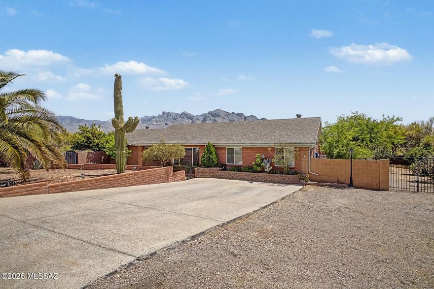 Exceptional nearly one-acre, no-HOA property in the heart of Oro Valley featuring stunning Catalina Mountain and Pusch Ridge views and a highly private setting. Situated on a premium corner lot backing to a wash, the property offers a rare sense of space with only one adjacent neighbor and a uniquely open, expansive feel. The large, block-enclosed backyard highlights incredible views and a pool with integrated waterfall and spa, multi-tiered areas, an expansive covered patio, gazebo, firepit, and built-in natural gas grill. Mature landscaping enhances privacy without obstructing the surrounding views, creating an ideal setting for both entertaining and everyday enjoyment. Inside, the home offers a 5-bedroom split floor plan with an open-concept design and extensive updates completed in 2020, including two additional bedrooms created from a permitted garage conversion. The kitchen features granite countertops and updated cabinetry, while the bathrooms include walk-in showers, updated cabinetry, and a deep soaking tub. Additional upgrades include porcelain wood plank flooring throughout, updated lighting, and modern fixtures. Improvements include a roof (2019), HVAC system (2020), water heater (2025), and induction range (2024). Ideally located near shopping, dining, and everyday amenities, this property offers a rare blend of space, privacy, views, and convenience in Oro Valley.