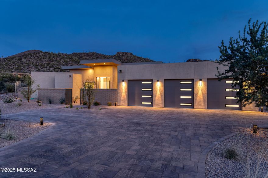 Brand-New Luxury Custom Home. Secluded 1.62-acre homesite showcasing sweeping saguaro studded mountain vistas. Experience the pinnacle of modern desert living in the guard-gated community of Canyon Pass at Dove Mountain. Designed for the discerning luxury buyer, the 4-bedroom, 5-bath residence offers soaring 14' ceilings, a chef's kitchen appointed with quartz countertops, high end appliances, and a statement island ideal for entertaining. The great room, highlighted by a linear fireplace and custom wood ceiling, extends through expansive glass sliders to a covered patio, resort-style pool, and spa, delivering an exceptional indoor-outdoor living experience. A rare chance to secure a new move-in-ready custom estate in one of Dove Mountain's most prestigious communities. The oversized garage is thoughtfully designed to accommodate a full-size luxury truck, including a GMC Sierra Denali (See photo gallery for illustration of an actual GMC Sierra Denali full size truck in the garage space).