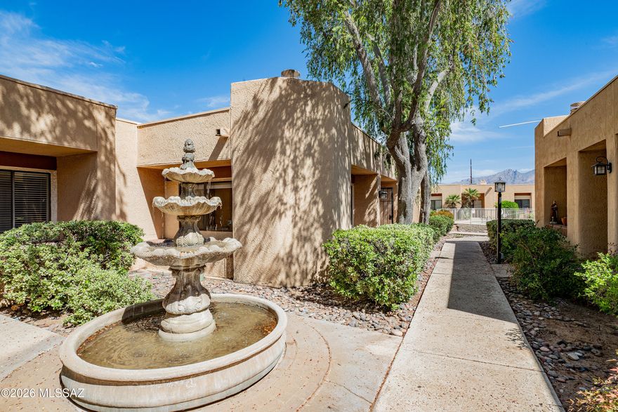 Secret-garden-like Midtown oasis features tranquil fountains, mature shade trees and a location that can't be beat. Easy driving distance to the U of A, TMC, Loft Cinema, cycling paths and a diverse mix of dining options. Townhome features sizable great room with gas fireplace, and abundant natural light. 2 BRs + den and 2 full baths; kitchen with electric oven/stove, dishwasher refrigerator and cheerful breakfast bar and discretely placed washer-dryer. Spacious walk-in closet; lots of storage; cozy private patio and 2-car garage. Gated community includes an electronic entry system, private courtyard, and swimming pool. New HVAC unit and hot water heater installed in 2024. Brand new Scandinavian-chic oak laminate flooring and fresh paint throughout. Come and see it for yourself!