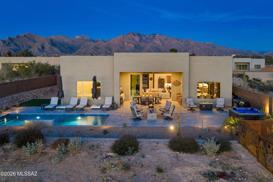 Surrounded by desert on a 1.2-acre parcel with compelling views of the mountains and sunset--yet close to the city center and abundant amenities. 5445 N Yvon Heights Place is tucked away in a small, gated enclave of only 12 homes that blends modern living with surrounding historic charm. With open space on all sides, this lot is private, unique and highly desirable. Completed in 2025, the property is effectively brand new and has been thoughtfully enhanced by the owner. Entering through an oversized glass pivot door, there is clear visual of the Tucson Mountains to the west and Catalina Mountains to the east. Airy spaces with high ceilings are appointed with large format tiles, designer lighting, well positioned windows, and a beautiful blend of neutral tones. The split floor plan includes 3 spacious bedrooms (all with ensuite baths), along with a den, office/flex space, and powder room. Whether the desired use is entertaining or a restful retreat, the layout is perfect for either. 

The great room seamlessly opens to the outdoor living area, which is truly magnificent. Everything to maximize desert life has been completed--the pool with a built-in fountain, silver travertine decking, gas firepit, synthetic grass area and the custom artistic metal panels. Extended fencing has created a huge yard, maximizing the views and offering unlimited potential.

This exceptional residence blends two lifestyles--desert living and city living. Heading north, there are trailheads to access the mountain, high end retail and grocery shops. Heading south it's easy to access Downtown Tucson, the University of Arizona, major hospitals and all the unique eateries and museums found in the Old Pueblo.