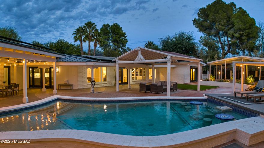 Situated on a premium interior lot in coveted, guard-gated Tucson Country Club Estates, where residents enjoy the best of Arizona living. This sprawling ranch-style burnt adobe home with a modern spin recently underwent an extensive interior renovation and has a new metal roof with new, owned solar panels. A private paradise awaits outside with the resort-style backyard shrouded in lush vegetation, & loaded with amenities. Extensive covered patios create the ultimate environment for year-round outdoor living. Fabulous outdoor kitchen with a built-in BBQ, fireplace with built-in seating, separate outdoor living & dining area, pizza oven, low-care turf area, a gorgeous pool with built-in seating, hot tub, and a sport court. Every inch of this property is finished, starting with the driveway and motor court, which have plenty of guest parking. A diamond-shaped red-brick walkway set in low-care turf bordered by red-brick flower beds leads to a charming courtyard with a fountain, a putting green, and a protected gardening area, creating a magnificent outdoor space to enjoy mountain views & sets the stage for the attention to detail throughout the home. Inside, vaulted tongue-and-groove ceilings and walls of windows showcase abundant natural light and the dreamy, picturesque backyard. Every detail is impeccably crafted, delivering a "wow" moment as you walk in. The classic and the new are carefully merged to retain the essence of the home while bringing it current. Spacious, open kitchen with Sub-Zero and Wolf stainless steel appliances, a center island with a breakfast bar, two dishwashers, two sinks & a wine refrigerator open to the great room with a wet bar, a gas fireplace, and custom built-ins. Just off the great room is an all-new powder room for guests. A den with a modern, built-in fireplace is a flexible space that separates the owner's suite from the main living area. The owner's suite is a private retreat with a fireplace, a new bathroom with a dual sink vanity, custom tile, a new separate vanity area, and an oversized walk-in closet with custom built-ins. The additional bathrooms have brand-new tile, fixtures, vanities, lights, mirrors, hardware, and more. The laundry room is large enough to be a flexible space with tons of storage, including a walk-in cedar closet, perfect for an office, craft room, gift wrapping, or whatever you need. The incredible backyard, which is rarely found, has a new corrugated metal fence with brick column anchors surrounding the entire backyard.

The unparalleled outdoor space presents unlimited opportunities for friends and family to gather & enjoy the Arizona lifestyle. A built-in hot tub that uses electricity generated by the owned solar panels, another massive metal ramada perfect for an outdoor gym or pickleball court, and a side yard with turf and a large net for practicing your golf swing or for pets. In addition to the epoxy-covered floor garage, there is an automatic gate that leads to another covered parking space that could serve as storage for another car. Tucson Country Club is a separate island in the city with a single point of access traversed by two major washes. Homeowners enjoy direct access to the renowned "Loop", a 133-mile interconnected, paved, car-free pathway for walking, running, and biking. Live 10 minutes from everything you need while escaping to your private sanctuary. Just 20 minutes from the University of  Arizona, less than 30 minutes to the Tucson Airport, and close to tons of shopping, great restaurants and bars, and hospitals.