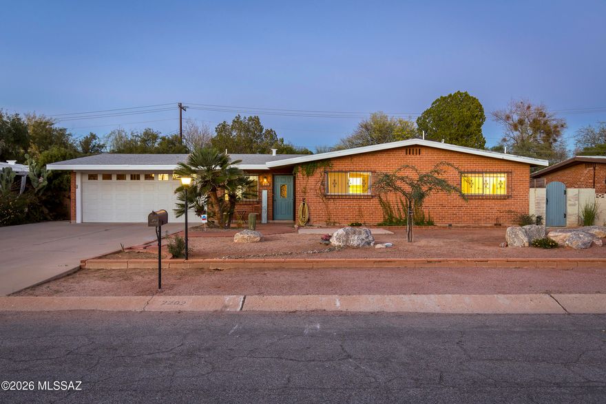 Charming double-brick home in a convenient central Tucson location, tucked into an established neighborhood. Main home features 2 bedrooms, 2 baths, a spacious great room with fireplace, and an expansive Arizona room spanning the back of the home for flexible living space. Wonderful galley kitchen offers ample workspace and functionality for everyday cooking and entertaining. Detached guesthouse with private entrance and full kitchen provides an ideal setup for multigenerational living, guests, home office, or rental income potential. Backyard includes a unique treehouse and room to enjoy outdoor living. Two-car garage with small workshop adds extra storage and functionality. A versatile property combining classic ranch style, solid construction, and income or guest opportunities.