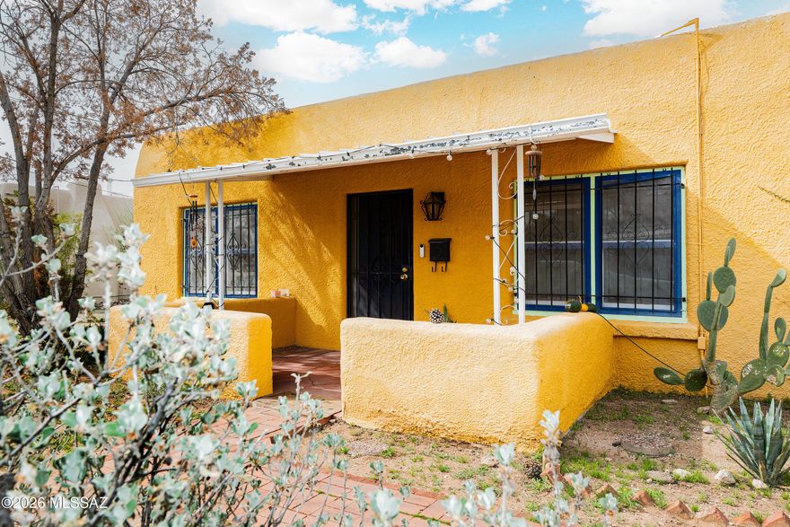 Charming Pueblo Revival home with classic southwest character, in convenient Palo Verde Neighborhood!  Super cute w/parquet floors in primary suite, living room, cozy fireplace, lots of natural light, french doors, archways, warm, light tile floors provide ez maintenance and a cohesive look. Delightful patio, spacious backyard with good room to relax, garden, entertain. Potential to build a 2nd unit. 1-car garage, plus a versatile bonus room behind the garage, ideal for workshop, hobby room, studio or additional storage. Conveniently located within walking distance to Catalina High, popular Izumi, Feast, Nur, Loft Cinema, Whole Foods, Miramonte, El Con Mall, and only~2 mi to U of A. Great opportunity for 1st-time buyers, students, investors or those wishing to live close to everything!