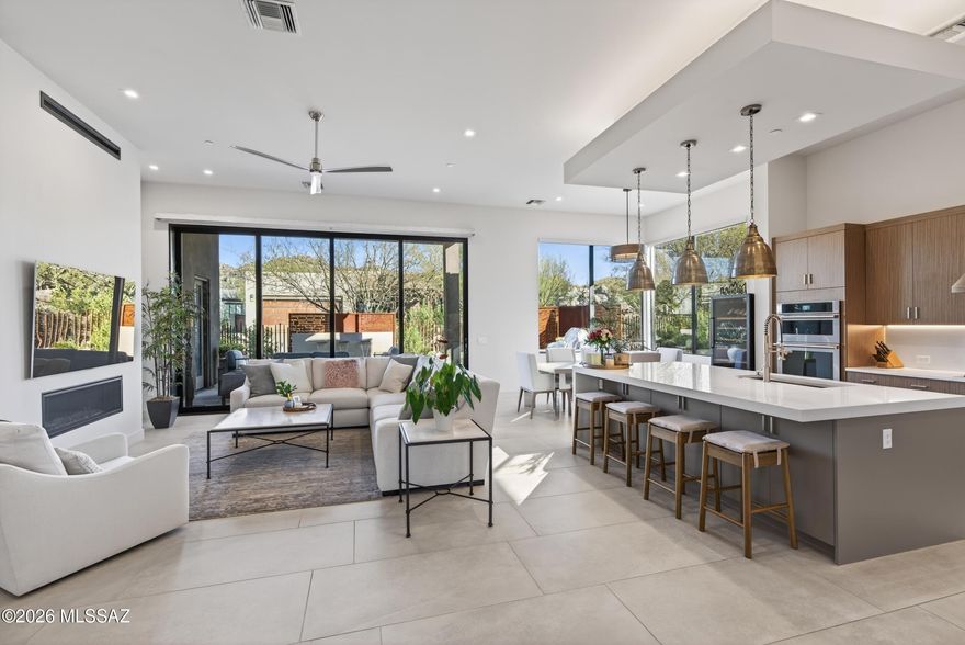 Tucked inside the prestigious Stone Canyon community, this semi-custom contemporary residence offers a seamless indoor-outdoor living experience with refined, high-end finishes throughout, just a short distance to the clubhouse and driving range. Featuring 3 bedrooms, 3.5 baths, and a flexible office/bonus space, every bedroom includes its own private en suite, ideal for comfort, privacy, and hosting.
A spacious open-concept layout welcomes you with soaring 12' ceilings, a stunning gas fireplace, and oversized 10' sliding glass doors that open to an extended covered patio with tile flooring that flows beautifully outdoors. The gourmet kitchen is designed to impress with stainless steel appliances, luxury finishes, and a massive center island perfect for entertaining. Step outside to a to a fully landscaped backyard oasis complete with a tranquil fountain and built-in outdoor grill, creating the perfect setting for Arizona living. Additional highlights include a whole-home water system, an extended garage on one side for extra storage or flexibility, a custom office build-out in one of the bedrooms, and custom garage cabinetry for exceptional organization and functionality.

Modern design. Luxury details. Prime Stone Canyon location.
