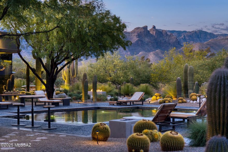 The Desert Retreat is an architectural masterpiece tucked away within the exclusive gates of Canyon Ranch in Tucson, AZ, showcasing a rare international collaboration between G & M Design of Monaco and Bart Reines of Miami. Brilliant minds and expert skills created this truly one-of-a-kind experience, blending quiet sophistication and elegance with the artful desert landscape. Meticulous attention to detail is shown throughout the residence, grounds, and private spa, all perfectly positioned on a 1.4-acre lot to maximize both views and privacy. Built to commercial standards with masonry construction, the contemporary lines with vertical and horizontal layers playfully interact with the organic shapes of the surrounding cacti. Intentionally, there is no clear path to the main entry; instead, a stroll through nature leads to a stately entrance, creating a beautiful contrast and a sense of discovery.

Stepping inside evokes a feeling of awe, yet there is an intrinsic calmness as every design element was purposefully selected to create a holistic and harmonious experience. Italian slab granite underfoot grounds the space, seamlessly connecting to the stone cladding on doors, cabinetry, and trim work. Thoughtfully placed throughout the home, a signature piece of custom artwork has been laser etched into the floors, while walls of oversized glass provide visual pathways to the landscape and natural separation between rooms. Every functional element is hidden from the eye, including venting, speakers, window coverings, power, and lighting controls, ensuring nothing interrupts the aesthetic.

Designed with four suites, each guest has an entirely private sanctuary appointed with custom furnishings, seagrass flooring, generous closets, and spa-like baths with views of the garden or mountains. Each suite may be independently controlled for light, temperature, and sound to ensure absolute comfort. Both grand in scale and surroundings, the salon showcases an interplay of neutral tones with layers of greenery outside. The indoors and outdoors unite in this magnificent space with floor-to-ceiling glass and cascading doors that disappear into the surrounding walls. While large groups are easily accommodated here, there are endless opportunities to create intimate settings as well.

Stepping outdoors, a world of tranquility is found within grounds blanketed in perfectly placed specimens of cacti, yucca, and grasses that create a botanical garden-like setting. Sitting above Sabino Creek with exposure to the Rincon, Catalina, and Santa Rita Mountains provides a unique environment both in terms of natural beauty and habitat. Low-lying giant Cottonwood trees and Mesquite bosques reside in contrast with the elevated saguaro, offering quiet moments for meditation, birdwatching, or reflection. A soul-soothing escape is found at the property's private pool and spa, nestled into the topography to feel cocooned while maintaining open sightlines to the mountains. Pebbles sourced from riverbeds and beaches of Southeast Asia blanket the pool and deck, providing both a soothing aesthetic and reflexology benefit.

Steps away, the wellness journey continues in a stand-alone spa building built to the standards of a 5-star resort, including an outdoor shower, steam room, and massage room. Each space was meticulously crafted to envelop the senses. This lifestyle is further enhanced by the amenities of the world-class Canyon Ranch Resort. Owners and their guests enjoy access to incredible facilities and an array of daily activities that include movement, mindfulness, and well-being. This is only the beginning, as the resort's experts include top professionals in medicine, nutrition, performance, longevity, and spirituality, ensuring each day can be a unique journey.