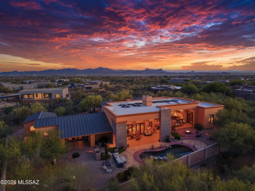 Behind the gates of an intimate enclave of just seven custom luxury homes, surrounded by mature Palo Verde trees and iconic Saguaros, sits a modern desert sanctuary where elegance, architecture, and nature live in Harmony. The over 4,000 sq. ft. custom residence offers the rare balance of privacy and close proximity to everyday conveniences_ groceries, dining, medical care, and services are only minutes away. From the moment you step through the 10-foot steel-and-glass entry, the home opens to dramatic volume and light. 18-foot ceilings and floor-to-ceiling glass draw the outdoors inward, while an 18-foot wall of folding doors transforms the great room into a seamless indoor-outdoor living experience. .  Morning light, desert breezes, and evening sunsets become part of the daily life. The gourmet kitchen impresses with professional Thermador appliances- dual microwaves, dual dishwashers, a warming drawer, five-burner gas cooktop, large refrigerator/freezer- all surrounded by rich custom cabinetry and expansive granite surfaces. Whether hosting dinners or lively gatherings, the space flows effortlessly into the great room, dining areas, and media/theater room. Throughout the home, attention to detail elevates every moment: Kohler fixtures, custom cabinetry in a warm wood tone, and whole-home audio with 18 speaker and multi-zone controls. Approximately 170 integral lights, plus landscape lighting, create ambiance day and night. The master suite offer the luxury of space and serenity, featuring a spa-inspired bath with eight-head electronically controlled walk-in shower, Jacuzzi tub and a generous walk-in closet. Guest rooms each include walk-in closets as well.
Outdoors, a resort-quality pebble pool and spa are joined by a cascading waterfall, enhanced by a secondary motor for dramatic effect. Solar heating extends the swim season from spring through fall, and the entire pool system can be controlled manually or from a smartphone- luxury with ease. A Remarkable Value: This home was originally built at a cost of just under $1.4M, and the cost to replicate it today would be $2.5-$2.7M. Yet it is offered at $1,750,000- significantly below construction value and an exceptional opportunity to own a luxury custom home at a price rarely seen in the current market. A Place For Celebration or Sanctuary: Here evenings glow with soft landscaping lighting and cascading water. The home easily becomes a gathering space for friend and family- or a private retreat for reflection and renewal.