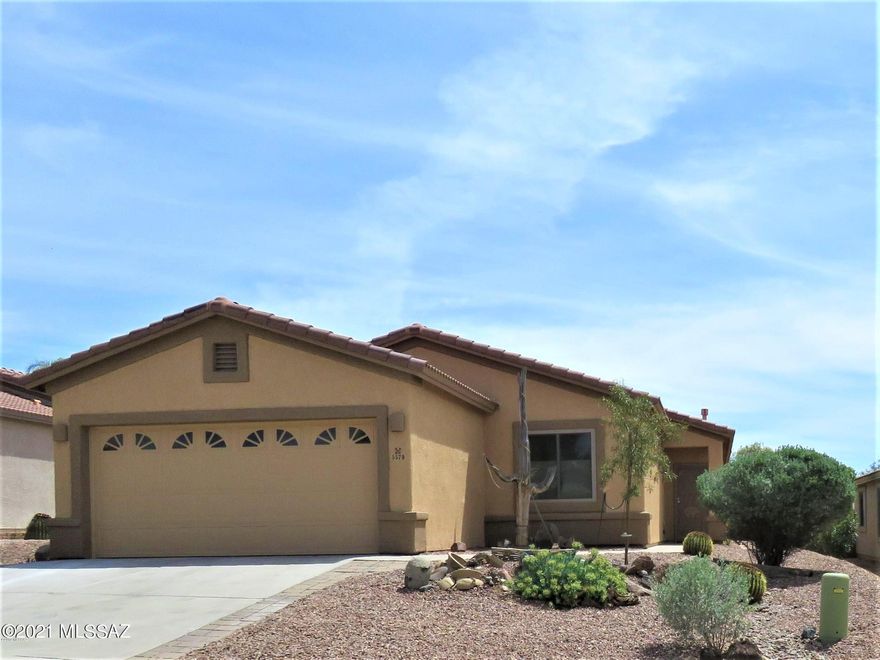Spacious great room plan with split bedrooms in Dove Mountain! This home has been updated, and features tile everywhere but 2 bedrooms, and the third bedroom has wood laminate flooring. Kitchen features quartz countertops, custom tile backsplash, stainless steel appliances including gas stove. Great room includes a gas fireplace with rocked front. Owners' suite includes walk in closet PLUS linen closet, and ceiling fan. Remodeled owner's suite bath with custom walk in shower, new vanity with quartz tops and LOADS of storage PLUS built ins behind. Hall bath was also remodeled with a generous use of tile, quartz and built ins.  Security screen graces the front door, and a water softener is included. Low care backyard includes Screen Porch. Tenant occupied until 5/31